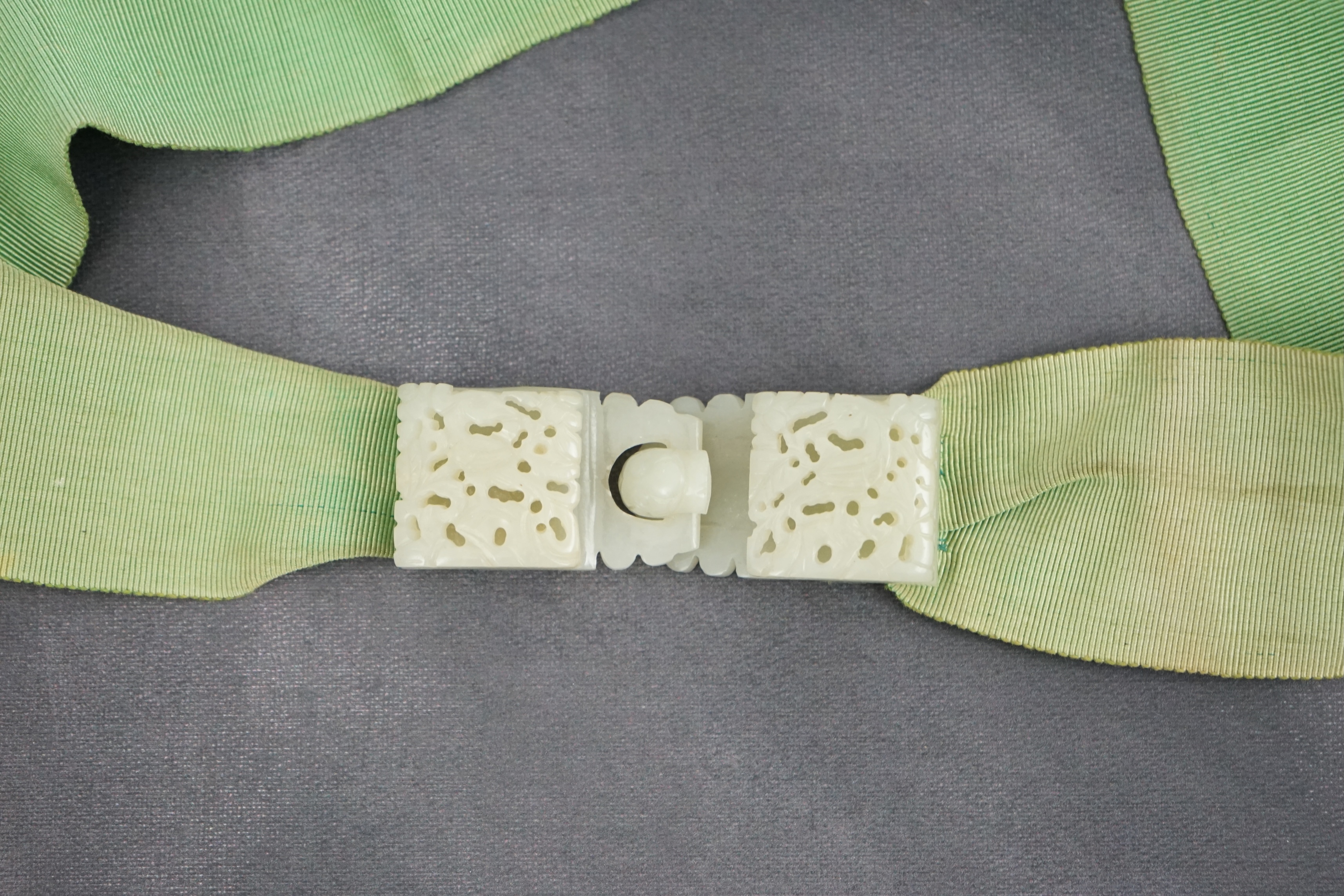 A Chinese pale celadon jade two-piece reticulated belt buckle, 19th century